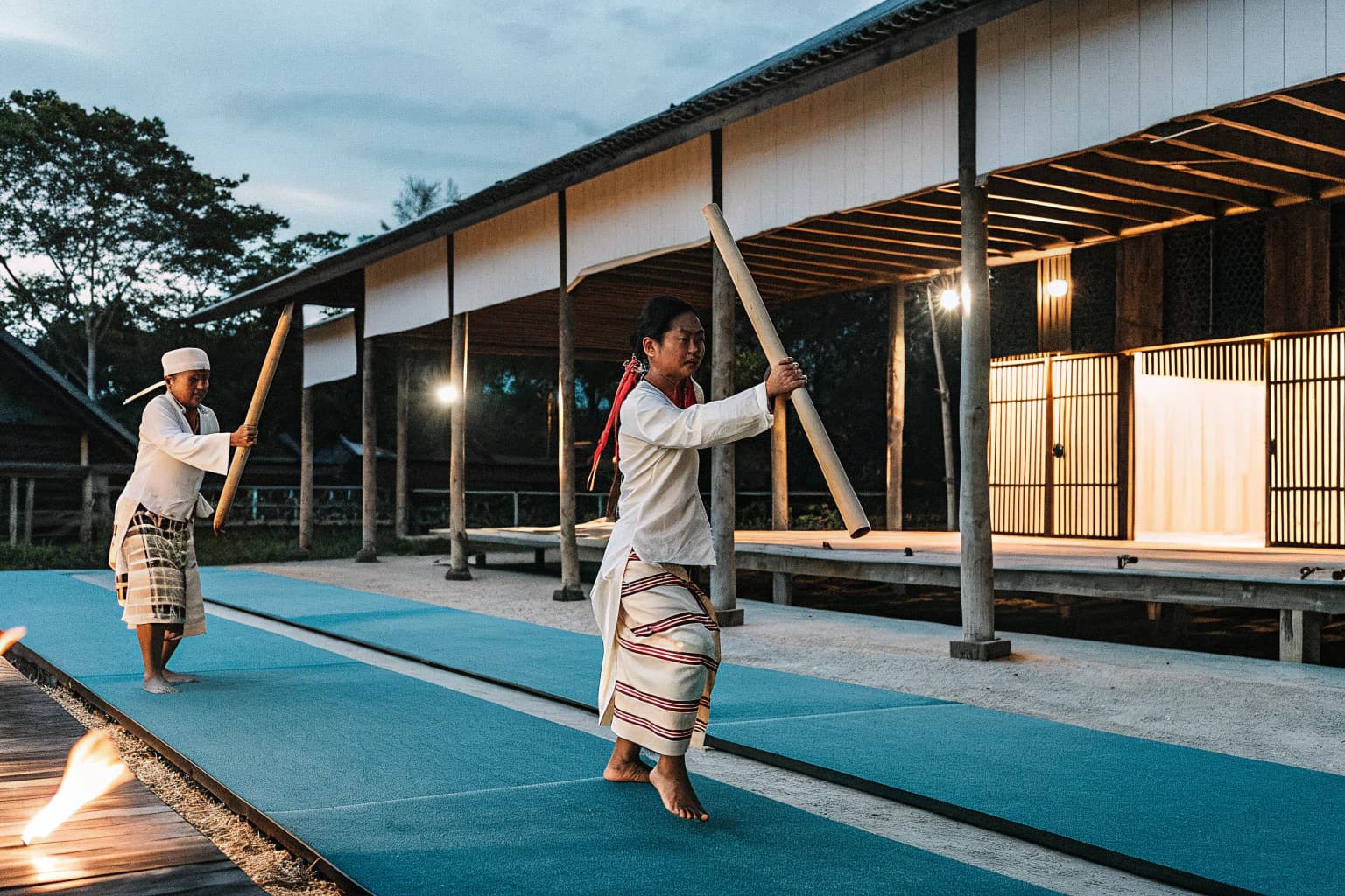 Cultural performers demonstrating bamboo dance at village longhouse